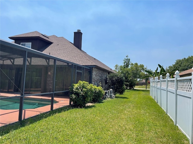 view of yard featuring glass enclosure, an outdoor pool, and fence