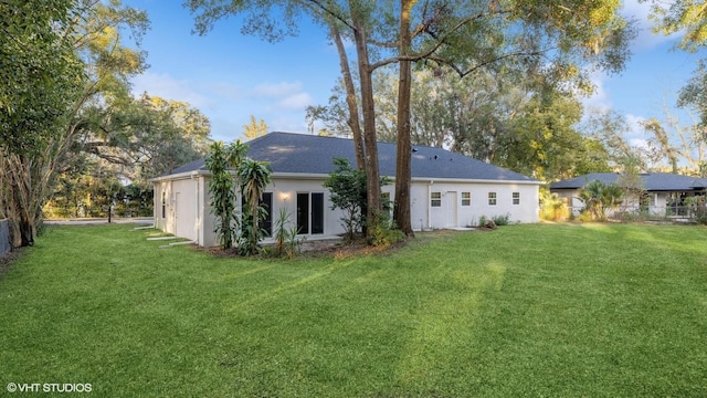 rear view of house featuring a yard