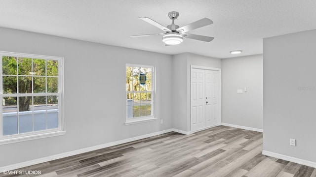 empty room featuring ceiling fan and light hardwood / wood-style floors