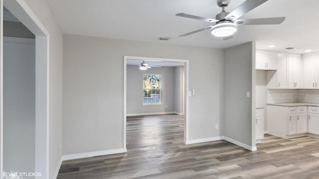 interior space with light stone countertops, light wood-type flooring, white cabinetry, and ceiling fan