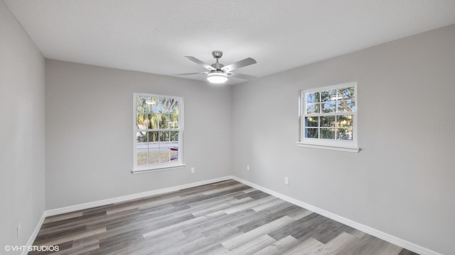 unfurnished room with wood-type flooring, a textured ceiling, ceiling fan, and a healthy amount of sunlight