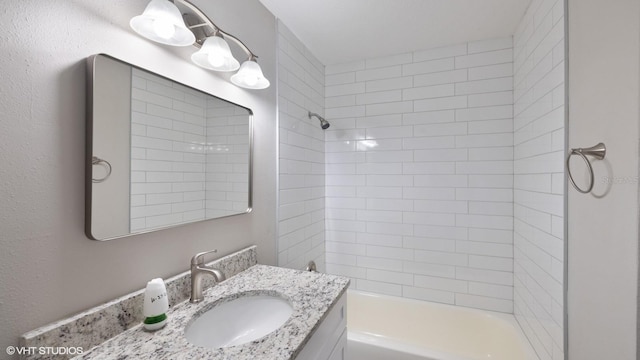 bathroom featuring vanity and tiled shower / bath