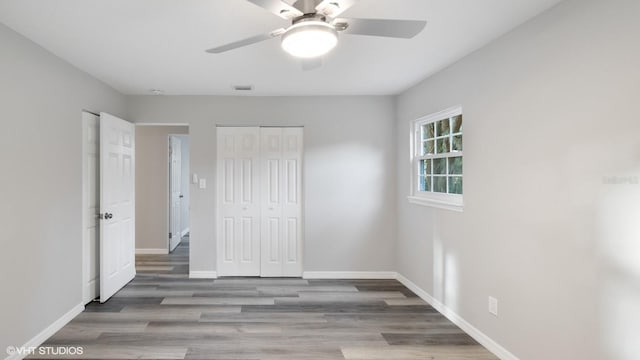 unfurnished bedroom with ceiling fan, light wood-type flooring, and a closet