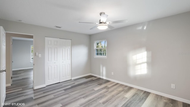 unfurnished bedroom with ceiling fan, a closet, and light hardwood / wood-style flooring