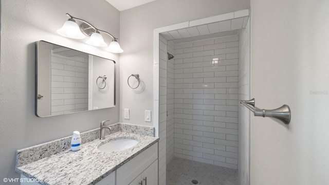 bathroom with vanity and tiled shower