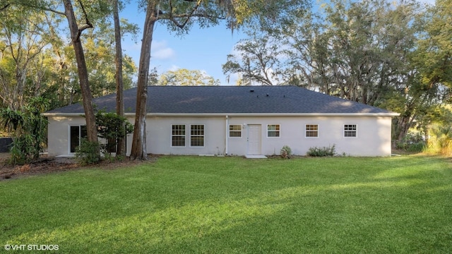 rear view of property featuring a lawn