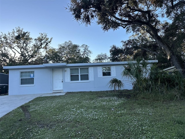 single story home featuring a front lawn