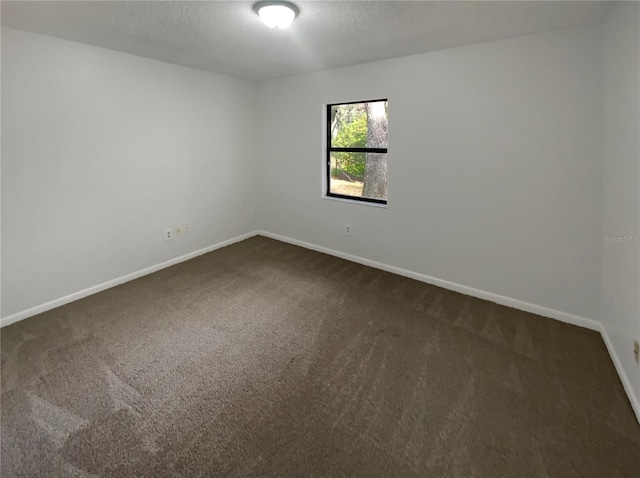 carpeted empty room with a textured ceiling