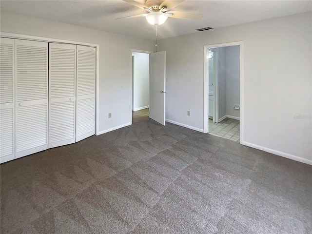 unfurnished bedroom with connected bathroom, ceiling fan, a closet, and carpet floors