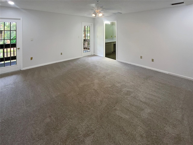 unfurnished room featuring ceiling fan and dark carpet