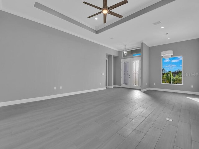 spare room featuring wood-type flooring, ceiling fan with notable chandelier, and ornamental molding