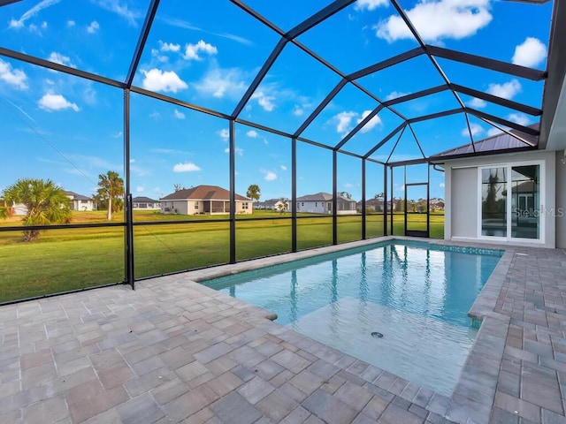 view of swimming pool featuring a lanai, a patio area, and a lawn