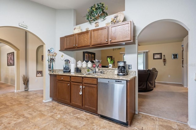 kitchen with light carpet, light stone countertops, a towering ceiling, sink, and dishwasher