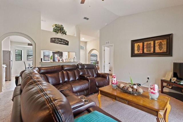 living room with ceiling fan, carpet floors, and vaulted ceiling