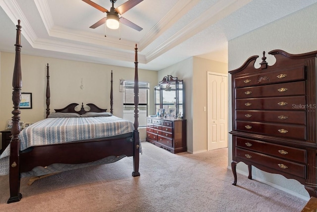 bedroom featuring a tray ceiling, ceiling fan, a closet, and light carpet