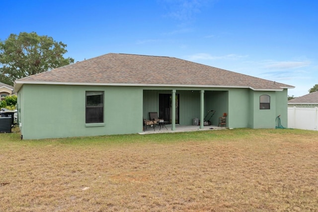 rear view of house featuring a lawn and a patio area