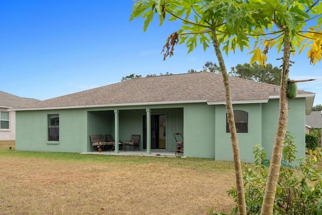 rear view of house with a yard and a patio