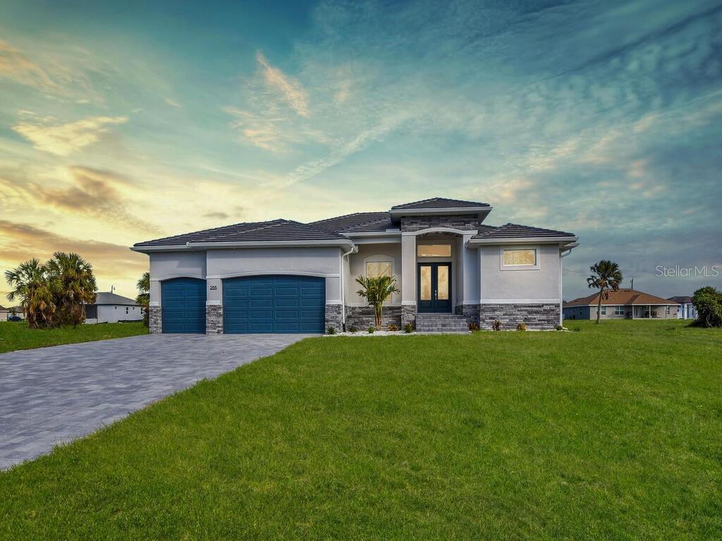 prairie-style home with a lawn, french doors, and a garage