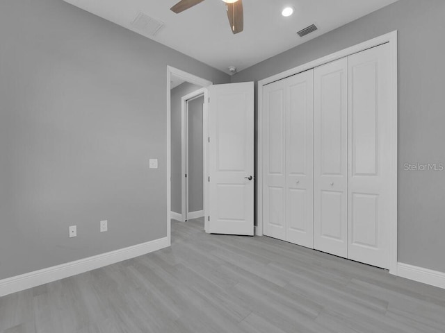 unfurnished bedroom featuring ceiling fan, light wood-type flooring, and a closet