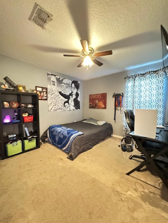 carpeted bedroom featuring a textured ceiling and ceiling fan