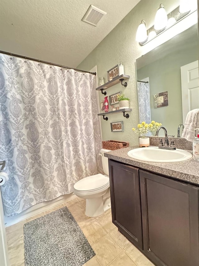 full bathroom with tile patterned flooring, a textured ceiling, toilet, shower / bath combo with shower curtain, and vanity