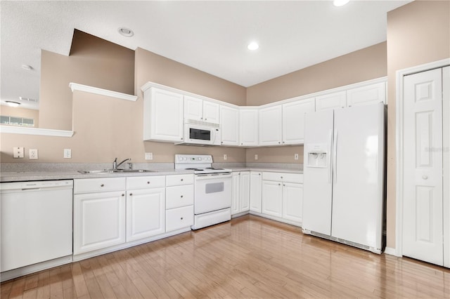 kitchen featuring white cabinetry, sink, and white appliances