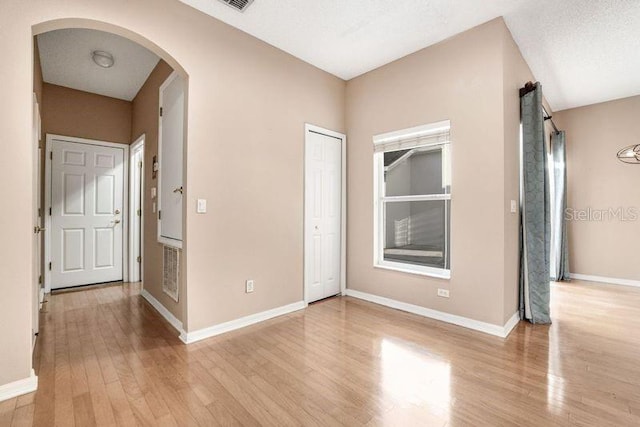 unfurnished bedroom featuring a textured ceiling and light hardwood / wood-style floors