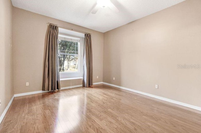 empty room featuring ceiling fan, a textured ceiling, and light hardwood / wood-style flooring