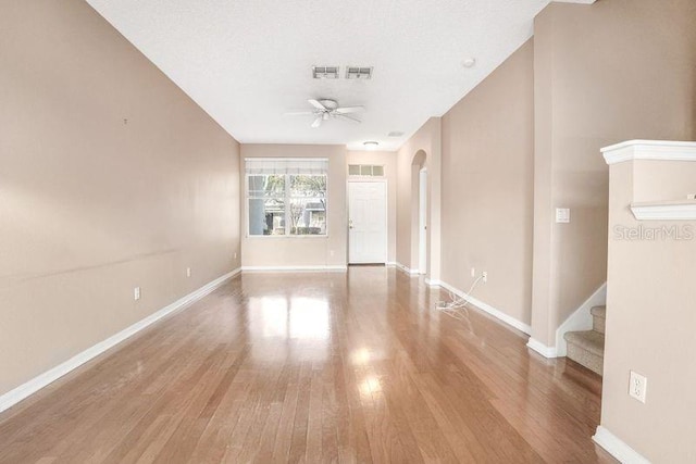 unfurnished room with ceiling fan, light hardwood / wood-style flooring, and a textured ceiling