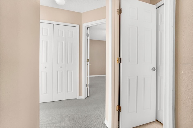 hall featuring light colored carpet