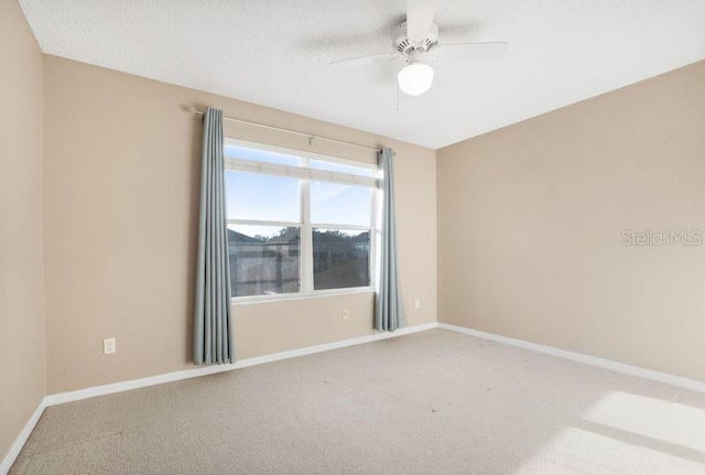 spare room featuring carpet, a textured ceiling, and ceiling fan