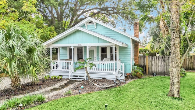 bungalow-style home with covered porch and a front yard