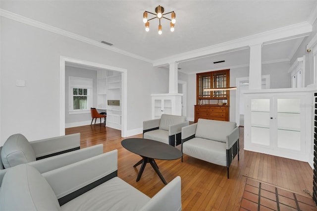 living room featuring hardwood / wood-style floors, crown molding, and a chandelier