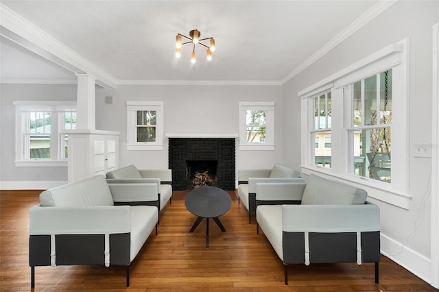 living room with crown molding, a wealth of natural light, a fireplace, and wood-type flooring