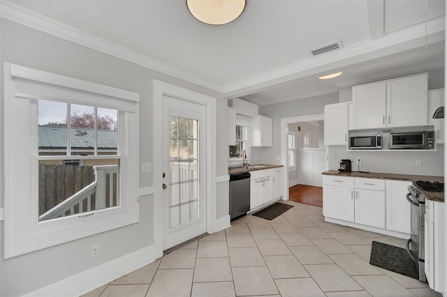 kitchen featuring white cabinets, sink, crown molding, light tile patterned floors, and appliances with stainless steel finishes