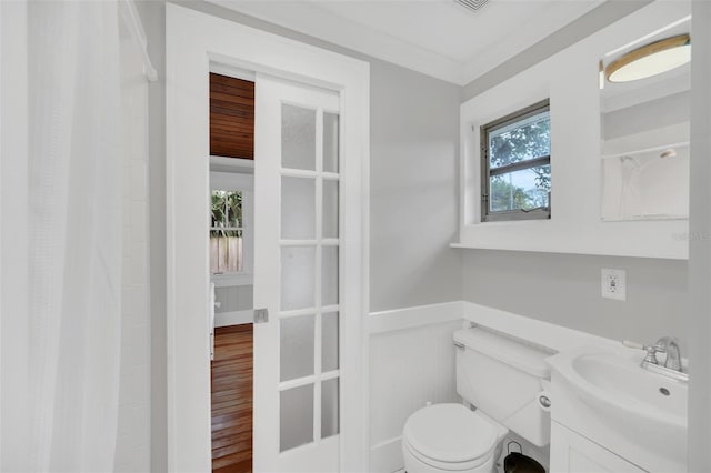 bathroom with wood-type flooring, vanity, toilet, and ornamental molding