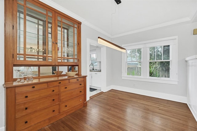 unfurnished dining area featuring dark hardwood / wood-style flooring and crown molding