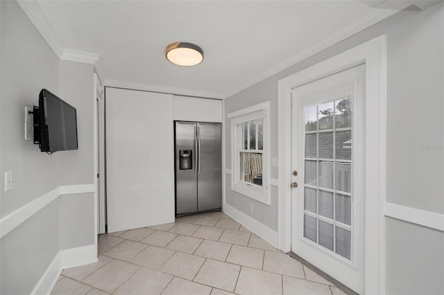 foyer with crown molding and light tile patterned flooring