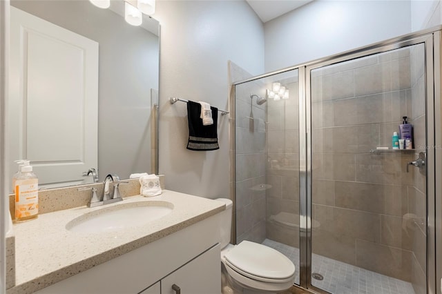 bathroom featuring vanity, toilet, and an enclosed shower