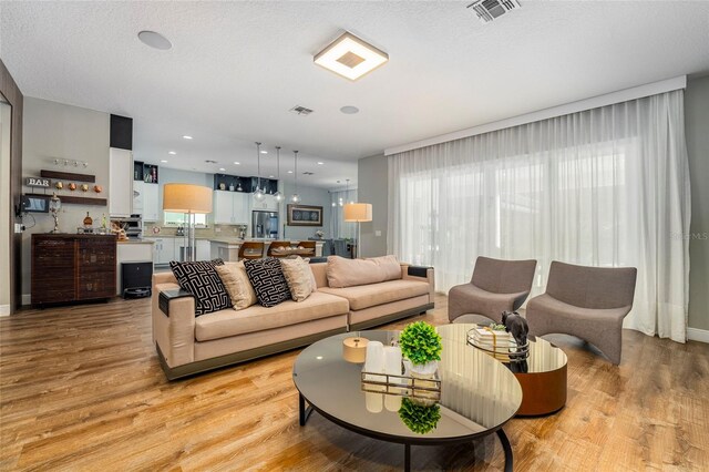 living room featuring light hardwood / wood-style floors and a textured ceiling