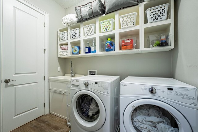 laundry area featuring sink, separate washer and dryer, and dark wood-type flooring