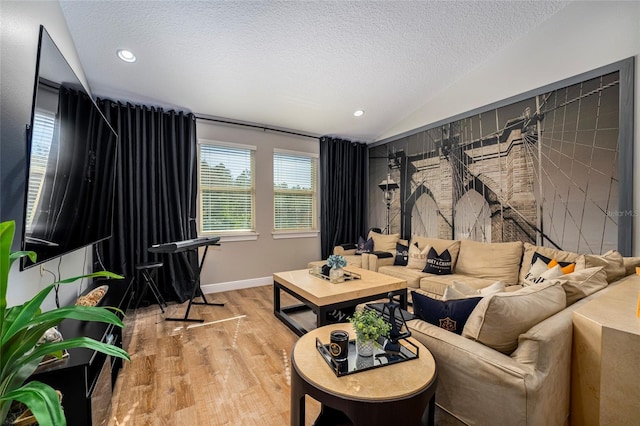 living room featuring hardwood / wood-style floors, a textured ceiling, and lofted ceiling