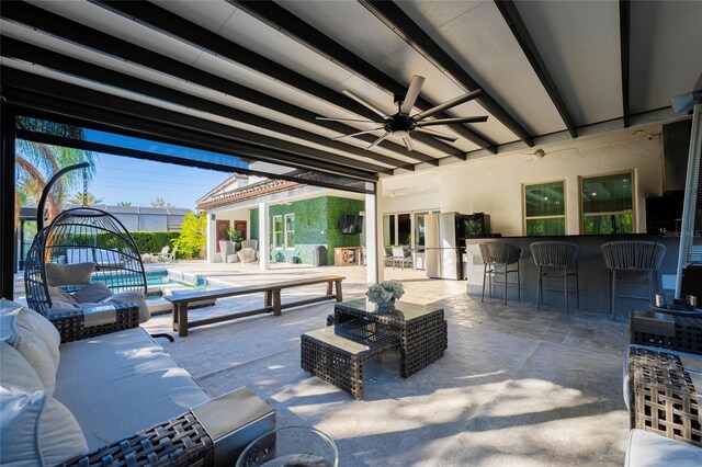 view of patio / terrace with an outdoor living space, ceiling fan, and a bar