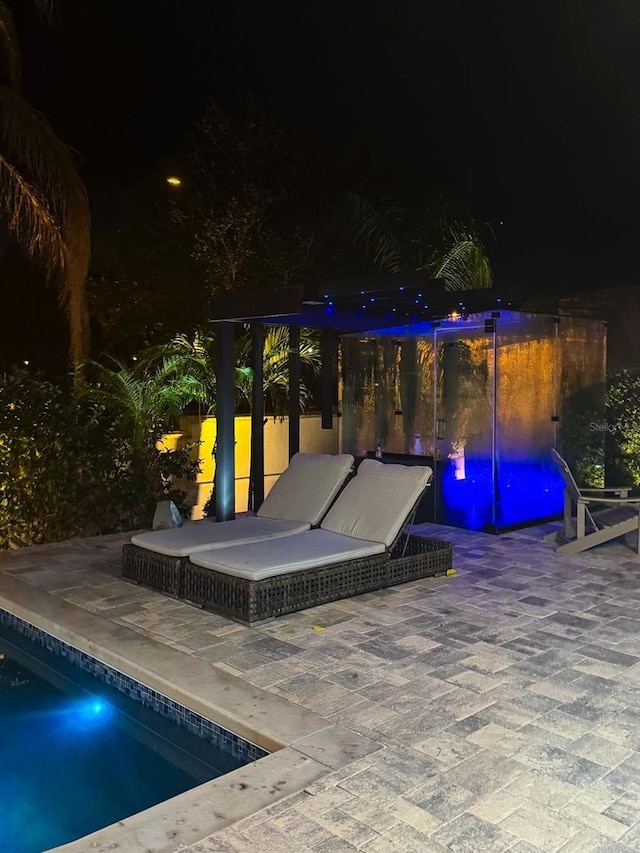 pool at twilight with a patio