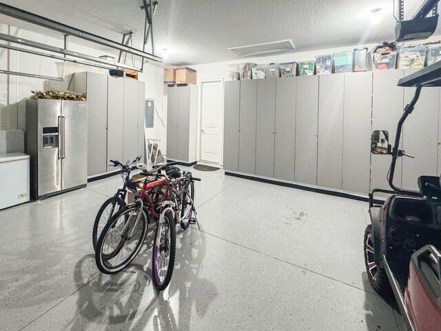 garage with stainless steel fridge, white fridge, and a garage door opener