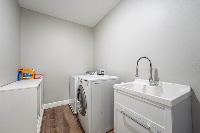 clothes washing area with cabinets, independent washer and dryer, and dark wood-type flooring