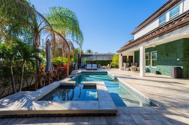 view of pool featuring an in ground hot tub and a patio