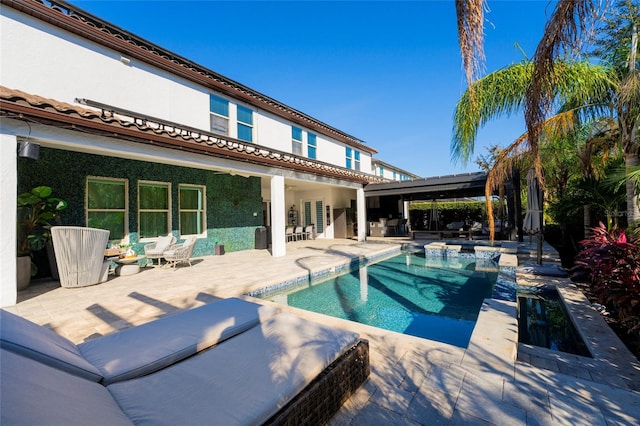 view of swimming pool featuring a patio area and exterior kitchen