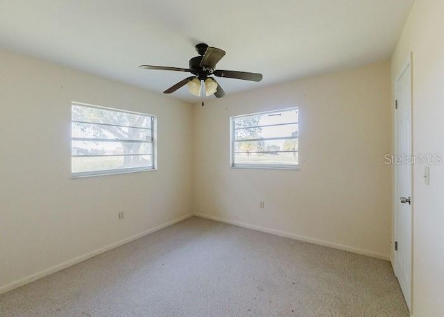 carpeted spare room featuring ceiling fan