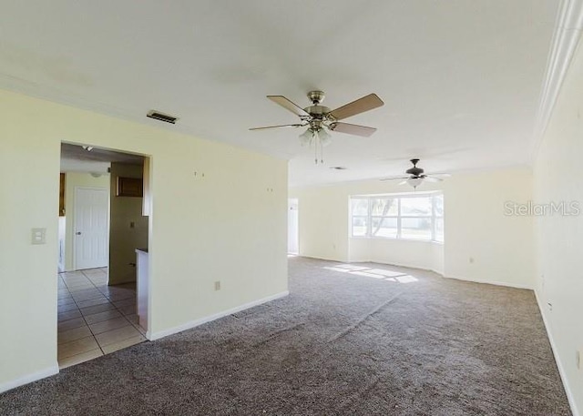 carpeted spare room with ceiling fan and ornamental molding